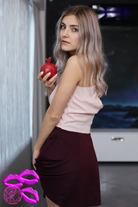 Julia, le charme mystérieux et son fruit défendu Julia, une belle femme de 30 ans aux yeux verts, de profil, tenant une grenade rouge pour intriguer et inviter à l'appel du désir.